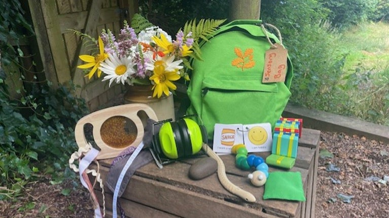 Green bag with lots of fun toys and helpful items